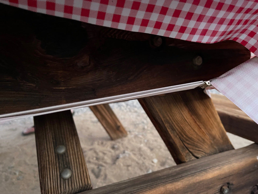 Wooden picnic camping table with outdoor tablecloth strap holding it in place