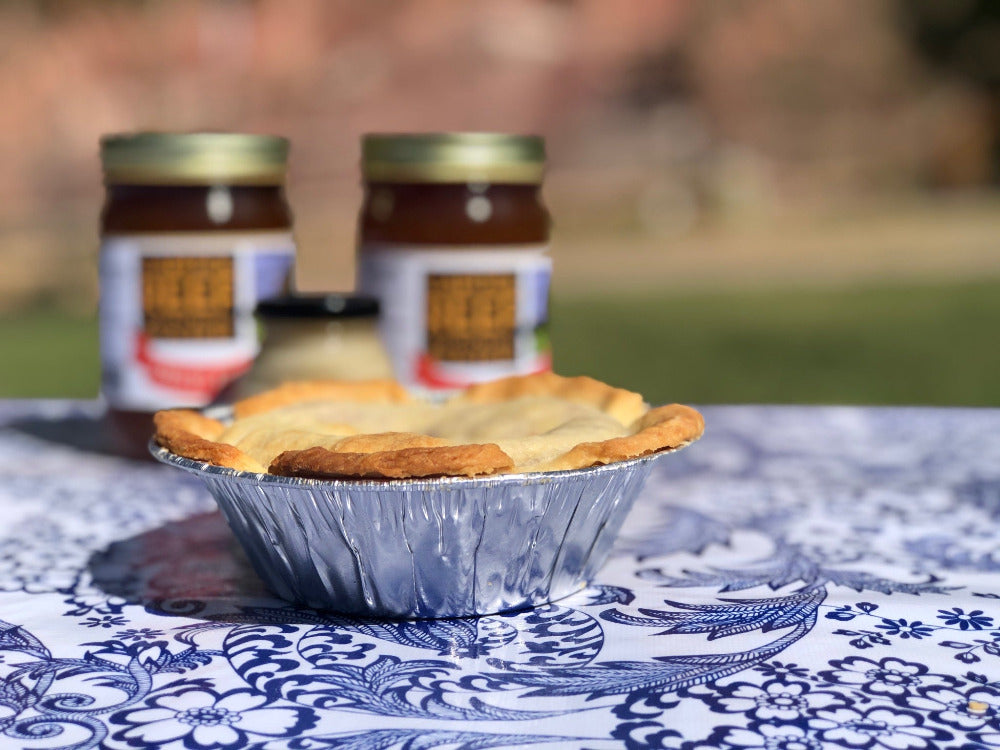 pie with pie tin on blue and white outdoor tablecloth