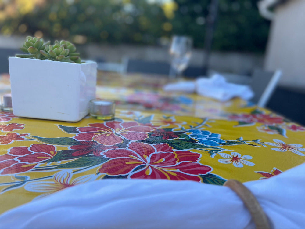 side view of a flower patterned outdoor tablecloth with planter and plant