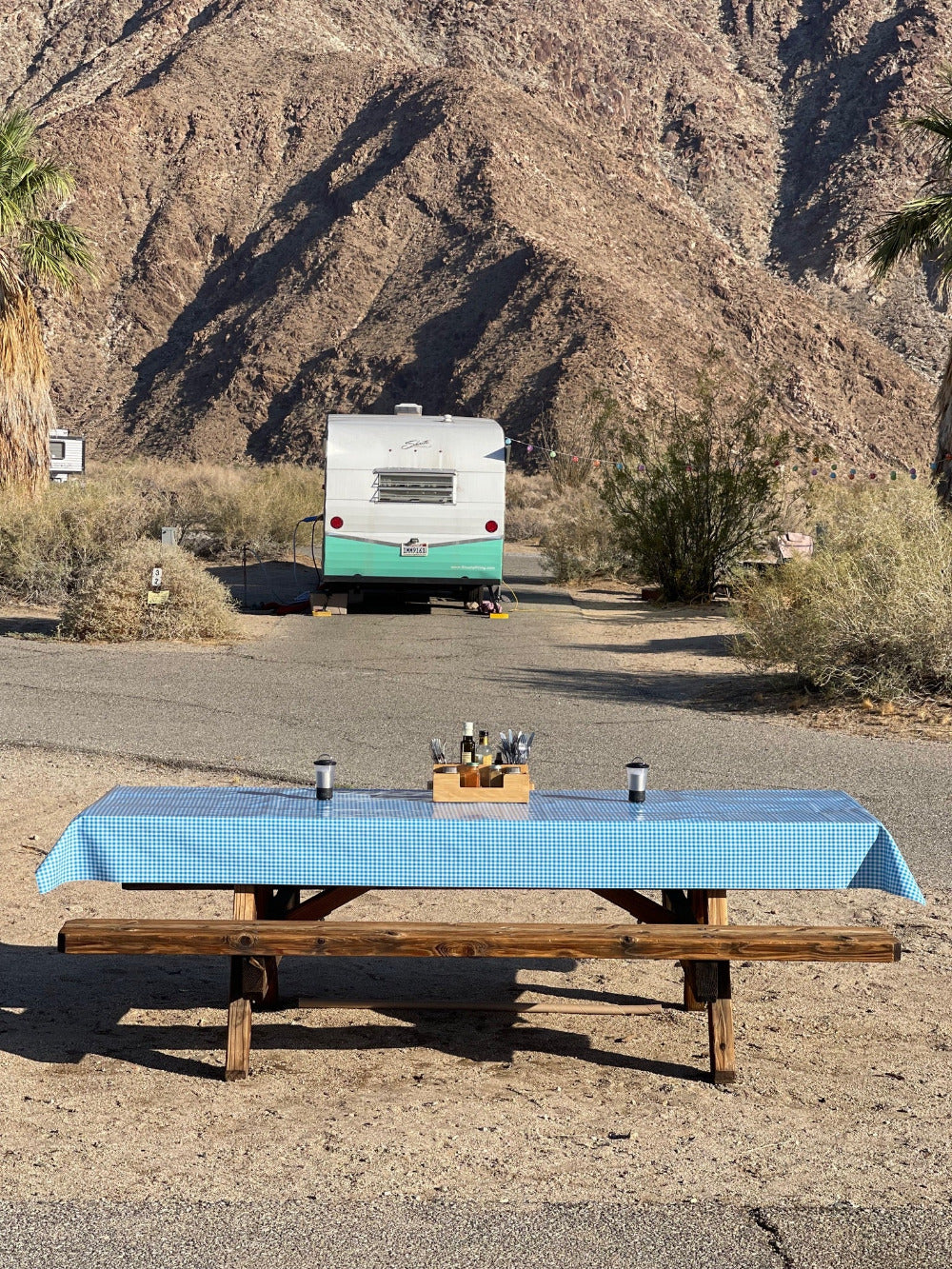 Blue and white outdoor tablecloth on a picnic camp site table at a desert campsite
